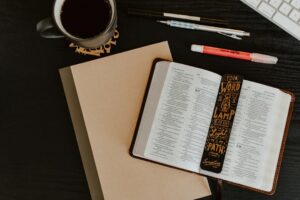 Open Bible with notebook and writing tools for studying Bible verses about time management
